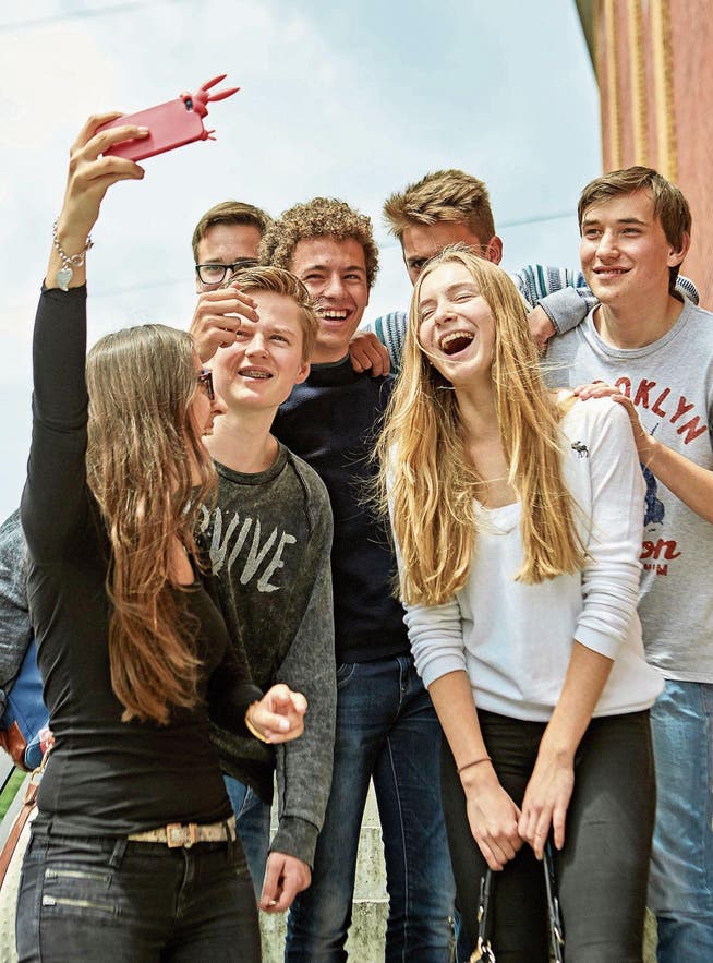 Eine Gruppe Jugendlicher macht mit einem Smartphone ein Selfie. (Bild: Christof Schuerpf/KEY)