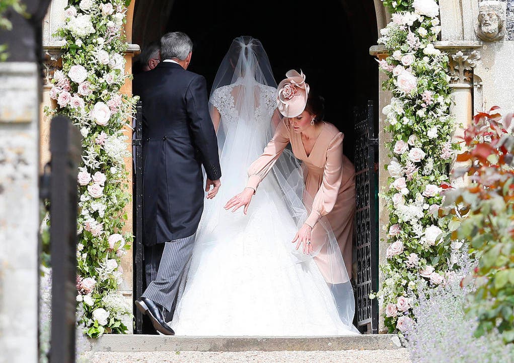 Kate, Duchess of Cambridge, richtet nochmals das Kleid von Pippa. (Bild: Keystone)
