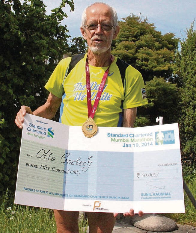 Marathonläufer Otto Götsch mit dem Siegercheck, den er 2014 für den ersten Rang in der Altersklasse «Super Veteran 65 plus» am Mumbai Marathon in Indien erhielt. (Bild: Christof Lampart)