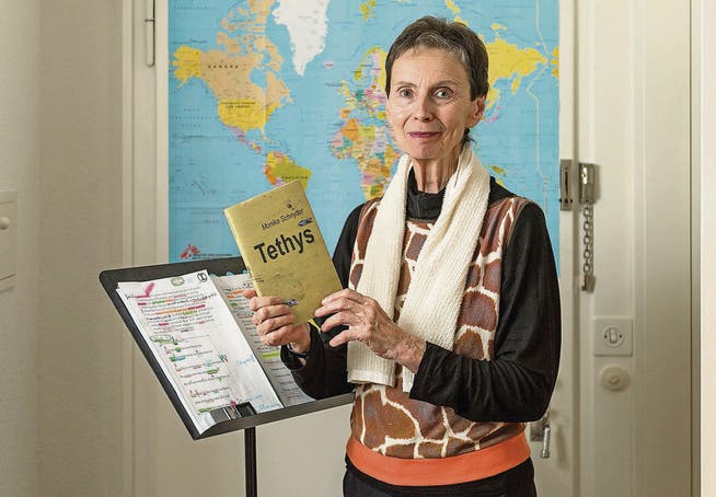 Weit gereist für ihren neuen Lyrikband: Monika Schnyder vor der Weltkarte in ihrer Wohnung, am Lesepult für die Vernissage stehend. (Bild: Hanspeter Schiess)