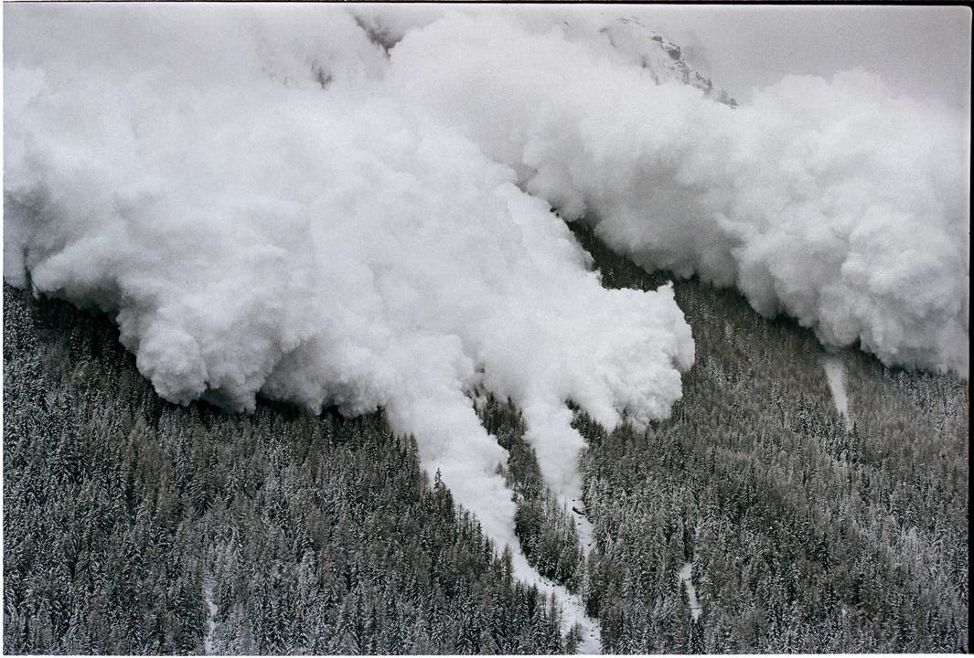 Eine mächtige Staub-Lawine donnert am 22. Februar 1999 neben dem Skigebiet Evolène, in den Schweizer Alpen, ins Tal runter. Einen Tag, nachdem eine Lawine in Evolène 12 Todesopfer gefordert hatte. Der heftigen Schneefälle wegen, haben sich bereits zahlreiche Lawinen spontan ausgelöst und töteten alleine im Monat Februar 19 Menschen. (Bild: Keystone/Fabrice Coffrin)