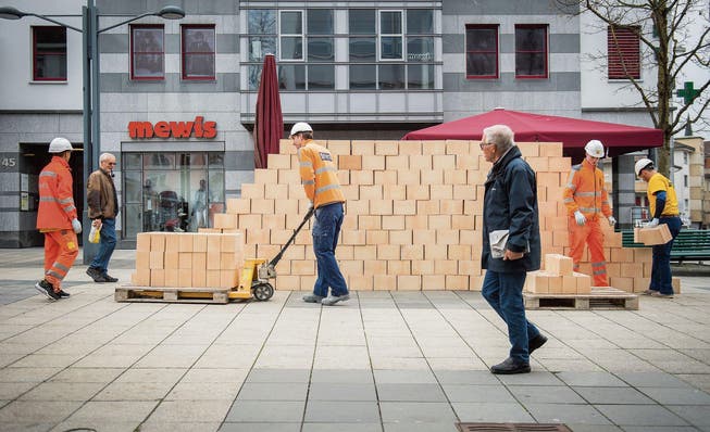 Symbolischer Mauerbau in Wil: Die Performance konfrontiert Passanten mit einem hochaktuellen Thema. (Bild: Urs Bucher)