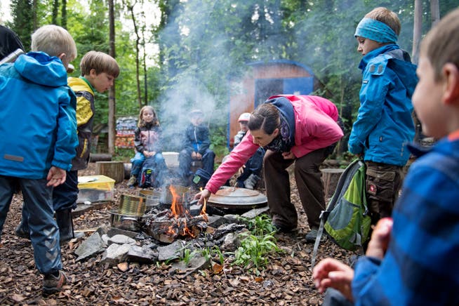 Kinder stellen kochend Waldmedizin auf dem Feuer im Wald her. (Bild Corinne Glanzmann, Alpmach, 15. Mai 2018). 