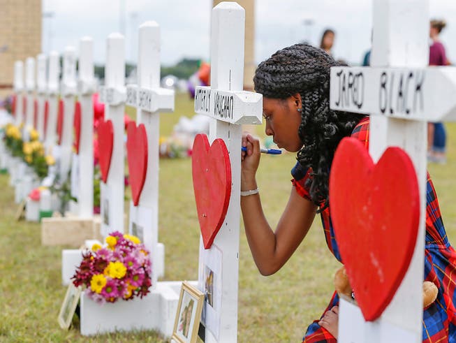 Eine Schülerin der Santa Fe High School schreibt eine Botschaft für ihre erschossenen Mitschüler. Der 17-jährige Amokläufer kannte alle seine Opfer. (Foto: Steve Gonzales/Houston Chronicle via AP) (Bild: KEYSTONE/AP Houston Chronicle/STEVE GONZALES)