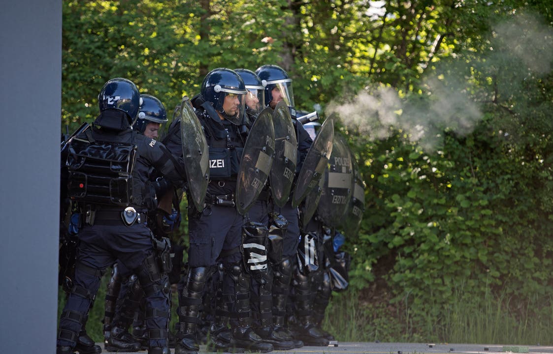Bei der Übung der Polizeikorps von Luzern, Nid- und Obwalden in Schüpfheim schützen sich Polizisten vor den Steinen der Aktivisten (Bild Corinne Glanzmann, 25. Mai 2018).