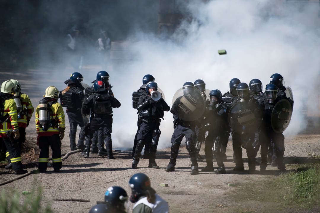 Polizisten proben in Schüpfheim den Ernstfall und schützen Feuerwehrleute vor Demonstranten (Bild Corinne Glanzmann, 25. Mai 2018).