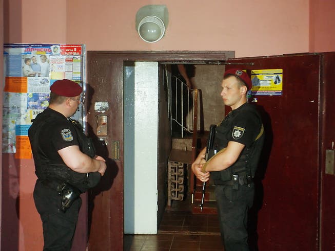 Alles inszeniert: Polizisten am vermeintlichen Anschlagsort in Kiew - einen Tag später spricht der angeblich erschossene Journalist Babtschenko vor den Medien. (Bild: KEYSTONE/EPA/STEPAN FRANKO)