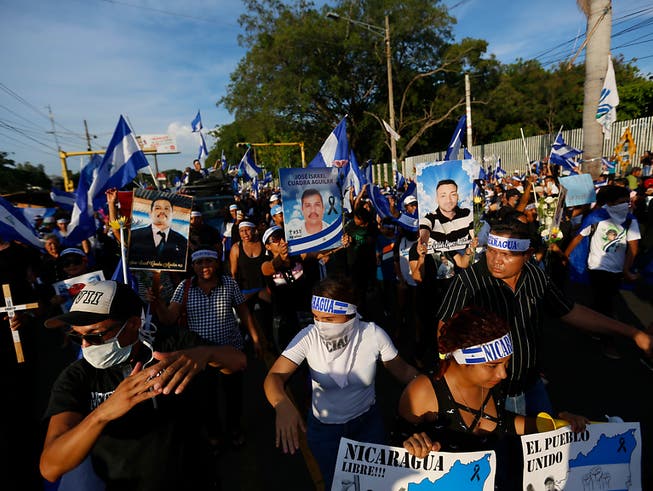 Demonstrierende in Managua mit Fotos von Personen, die bei früheren Kundgebungen in Zusammenstössen mit der Polizei getötet wurden. (Bild: KEYSTONE/AP/ALFREDO ZUNIGA)