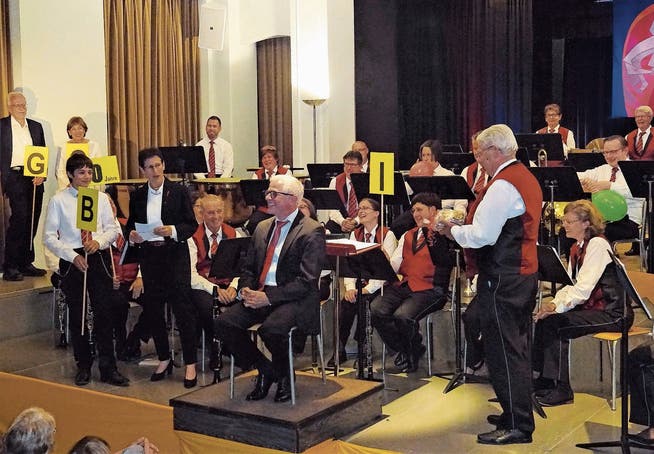 Dirigent Guido Weber (Mitte) erhielt am Konzert ein Geschenk für sein Jubiläum. (Bild: Flavia Niederberger; Engelberg, 16. Juni 2018)