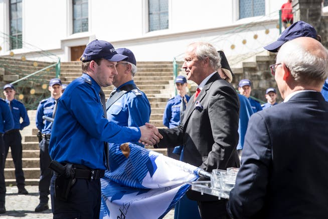 Justiz- und Sicherheitsdirektor Paul Winiker gratuliert dem frisch vereidigten Polizisten Dominik Ettlin. (Bild: Manuela Jans-Koch, Sursee, 24. Mai 2018)