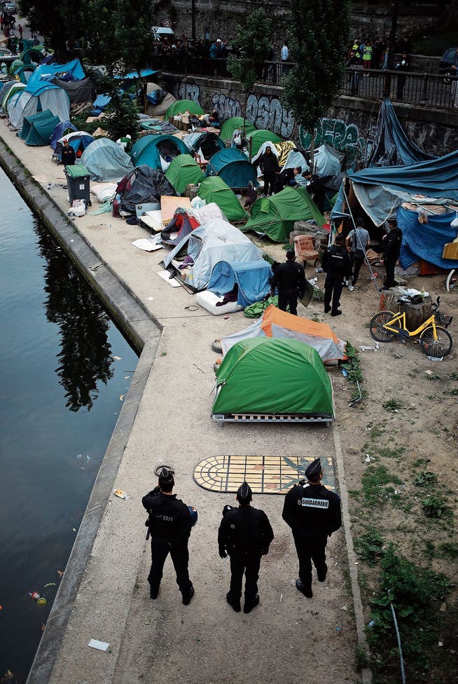 Polizisten beobachten die Räumung eines Flüchtlings-Zeltlagers in Paris. (Bild: François Mori/AP (4. Juni 2018)
