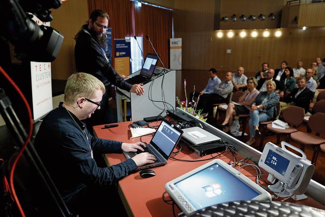 Fabian Riechsteiner (vorne) und Stefan Peter zeigen dem Publikum, wie sie in ein IT-System eindringen. (Bild: Stefan Kaiser (Rotkreuz, 7. Juni 2018))