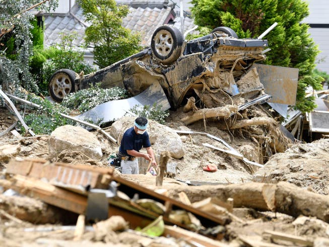 Japans Regierungschef Shinzo Abe machte sich am Mittwoch ein Bild von den Zerstörungen nach dem Unwetter in seinem Land. (Bild: KEYSTONE/AP Kyodo News/RYOSUKE OZAWA)