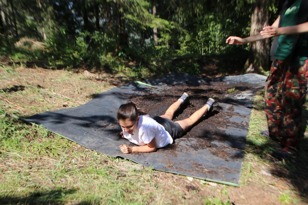 Auf dem Militärparcours: Ein Mädchen des Blaurings Sachseln robbt in Schwarzsee FR durch den Schlamm. (Bild: Samira Gasser)