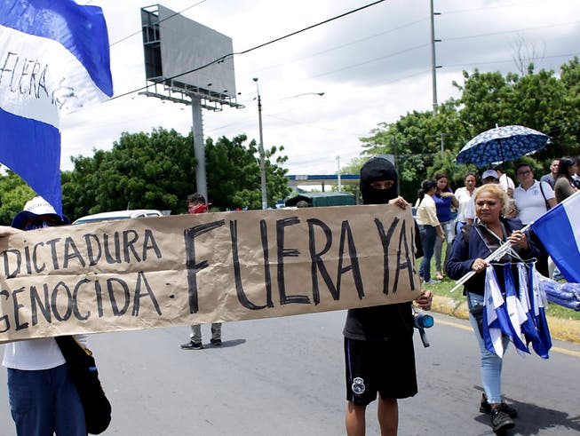 «Völkermörderische Diktatur raus!» steht auf einem Transparent von Protestierenden in den Strassen von Managua, der Hauptstadt Nicaraguas (Aufnahme vom 30. Juli 2018). (Bild: KEYSTONE/AP/ARNULFO FRANCO)