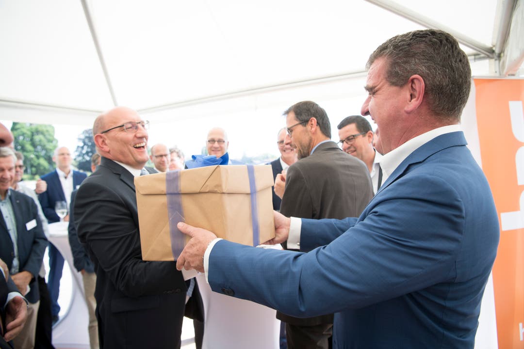 Stadler-Inhaber und Verwaltungsratspräsident Peter Spuhler überreicht die Baubewilligung in der Schachtel an HRS-CEO Martin Kull.