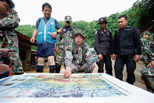 Förster werten auf der Suche nach Bohrmöglichkeiten zur Höhle eine Karte aus. (Bild: Rungroj Yongrit/EPA)