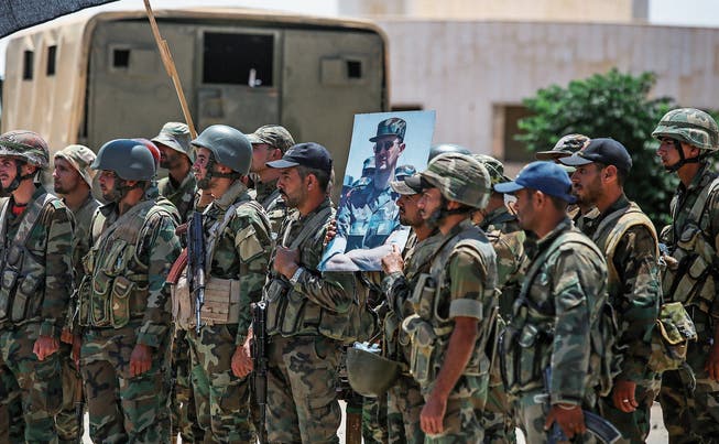 Syrische Soldaten halten ein Bild Baschar al-Assads in die Höhe. (Bild: Youssef Karwashan/AFP (Daraa, 7. Juli 2018))