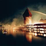 Gespenstischer Anblick: Die brennende Kapellbrücke mitten in der Nacht – die Löscharbeiten sind noch im Gang. Es ist das meist abgedruckte Bild des Brandes. (Bild: Ruth Tischler (Luzern, 18. August 1993))