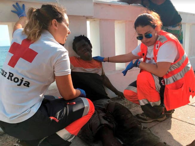 115 Flüchtlinge überwinden den Grenzzaun in Ceuta: Rot-Kreuz-Helferinnen behandeln einen von ihnen. (Bild: KEYSTONE/EPA EFE/JOSE M. RINCON)