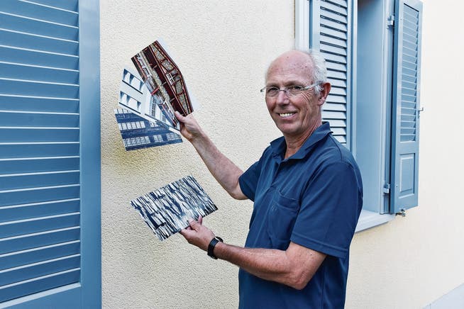 Ralph Brühwiler präsentiert vor seinem frisch renovierten Haus in Ebnat-Kappel die Prototypen der Karten, die er für sein Krinauer Kunstprojekt anfertigen lässt. (Bild: Anina Rütsche)