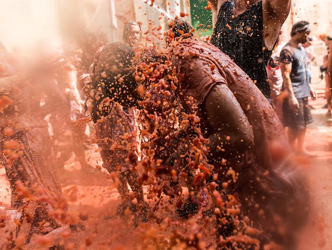 Mehr als 20'000 Menschen haben in Bunol bei Valencia an der traditionellen Tomatenschlacht teilgenommen. 145 Tonnen überreife Tomaten wurden dabei herumgeworfen. (Bild: KEYSTONE/EPA EFE/RODRIGO JIMENEZ)