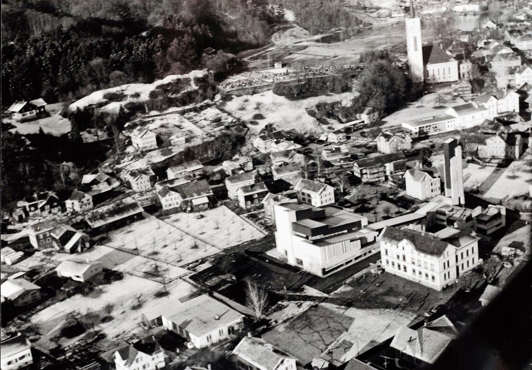 Blick aus dem von Pfarrer Oswald pilotierten Flugzeug mit Sicht auf die beiden Kirchen und das Schulhaus Grof.