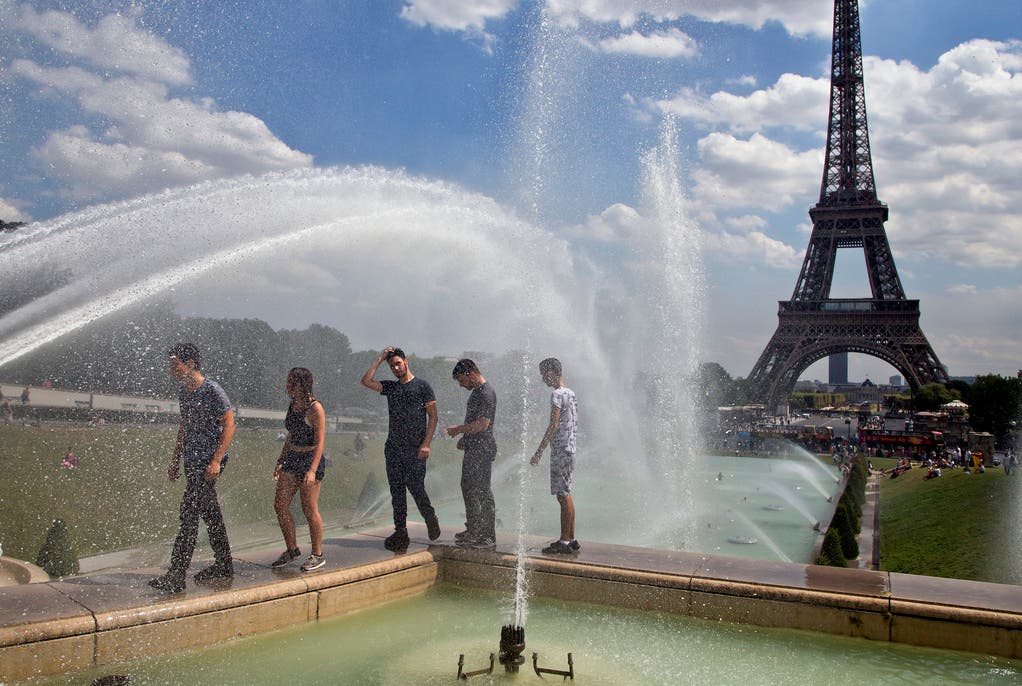 Erfrischung mit Aussicht: Beim Pariser Eiffelturm suchen Touristen nach einer Abkühlung. (Bild: Keystone)