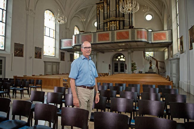 Kirchenpräsident Martin Dudle inmitten der neuen Stühle der Pfarrkirche Hergiswil. (Bild: Corinne Glanzmann (Hergiswil, 31. Juli 2018))