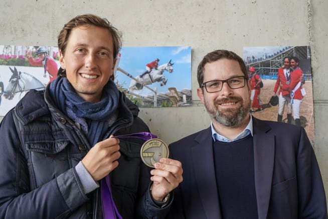 Martin Fuchs posiert im Reitstall mit seiner Silbermedaille und dem Wängemer Gemeindepräsidenten Thomas Goldinger. (Bild: Maya Heizmann)
