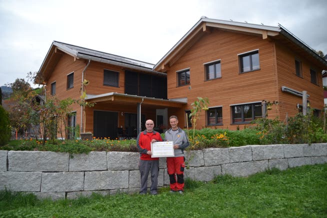 Bauherr und Architekt Ernst Giger (links) und Hansjörg Roth mit dem Diplom «PlusEnergieBau». (Bild: Adi Lippuner)