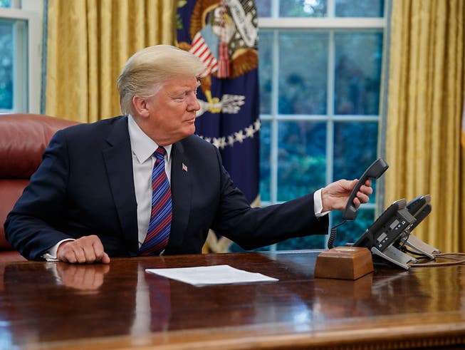 US-Präsident Donald Trump beendet ein Telefongespräch im Weissen Haus. (Bild: KEYSTONE/EPA/SHAWN THEW)
