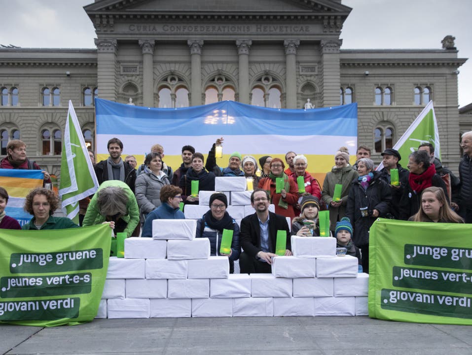 Balthasar Glättli (GPS/ZH) und Aline Trede (GPS/BE) posieren mit Mitgliedern der Grünen und jungen Grünen bei der Einreichung der Gletscherinitiative am Mittwoch auf dem Bundesplatz in Bern. (Bild: Keystone/PETER KLAUNZER)