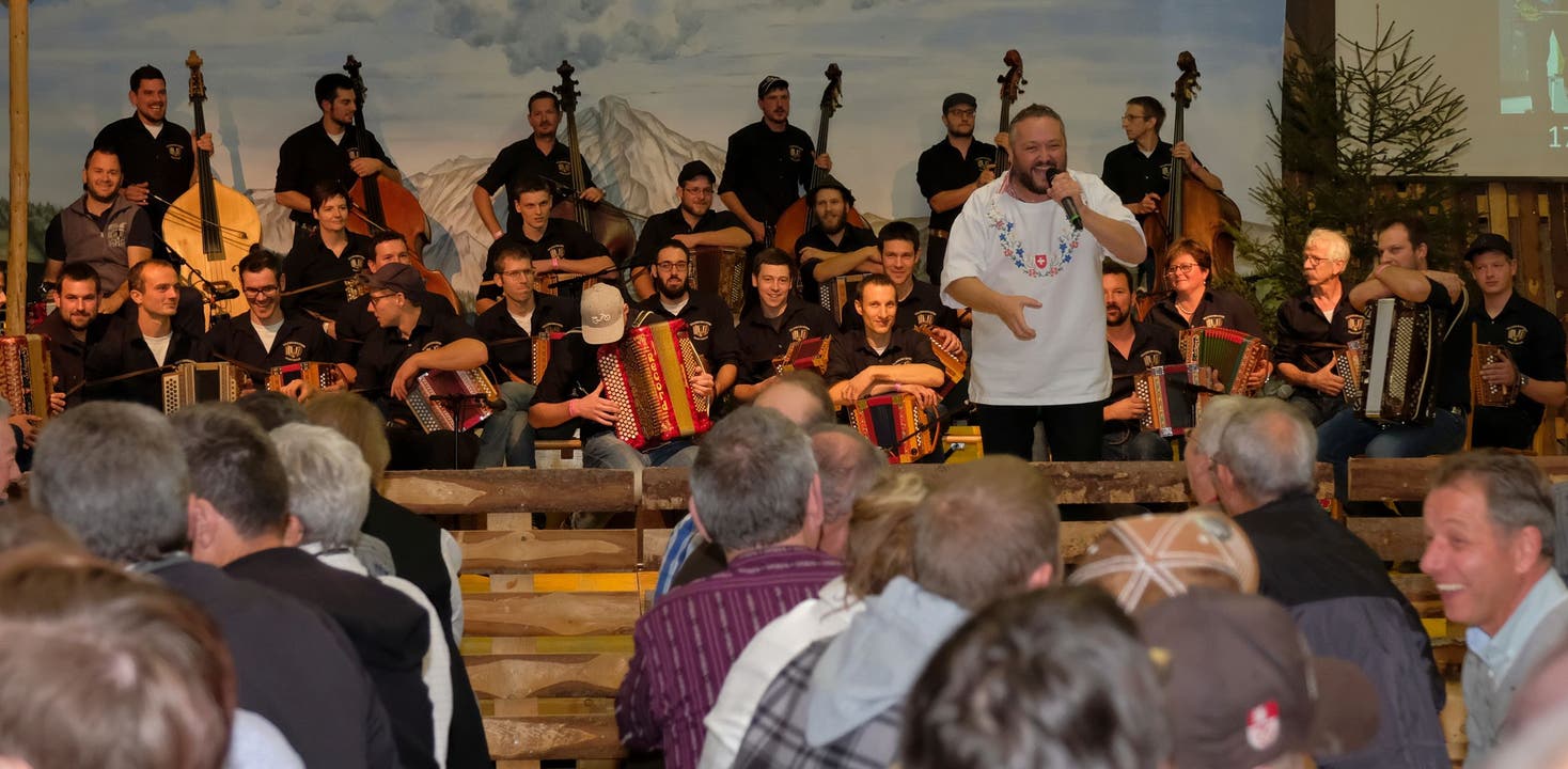 Moderator Frowin Neff stellt den Volksmusikverein Ennetmoos vor, der sein 20-jähriges Bestehen feierte. (Bild: Richard Greuter, Ennetmoos, 2. November 2019)