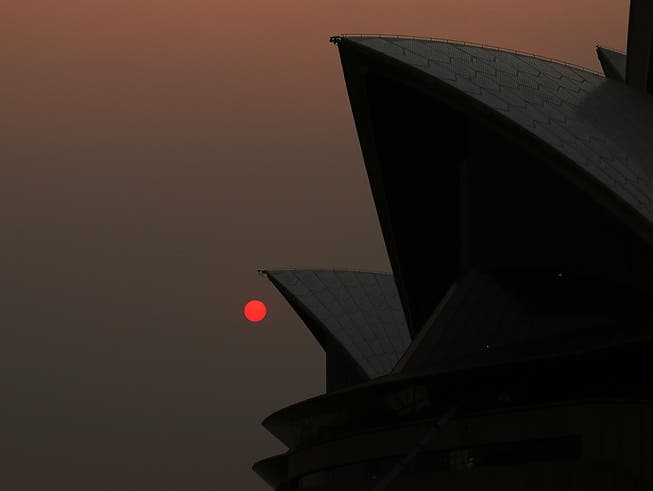 Rauch in der Metropole Sydney färbt die Sonne tagsüber rot. Im Bild: Das Opera House.