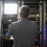 Ein Informatiker kontrolliert einen Server. (Key, Gaetan Bally)