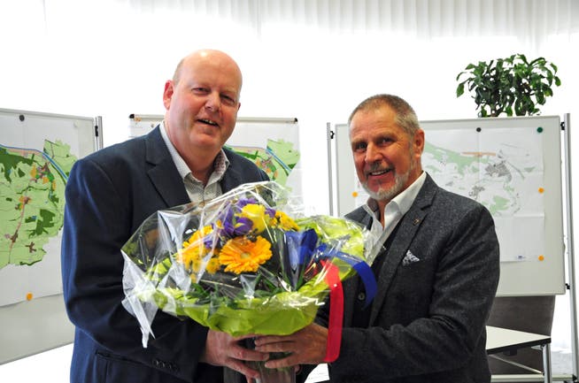 Der abtretende Gemeindepräsident Othmar Schmid übergibt seinem Nachfolger Thomas Ochs (links) die Blumen. (Bild: Sabrina Bächi)