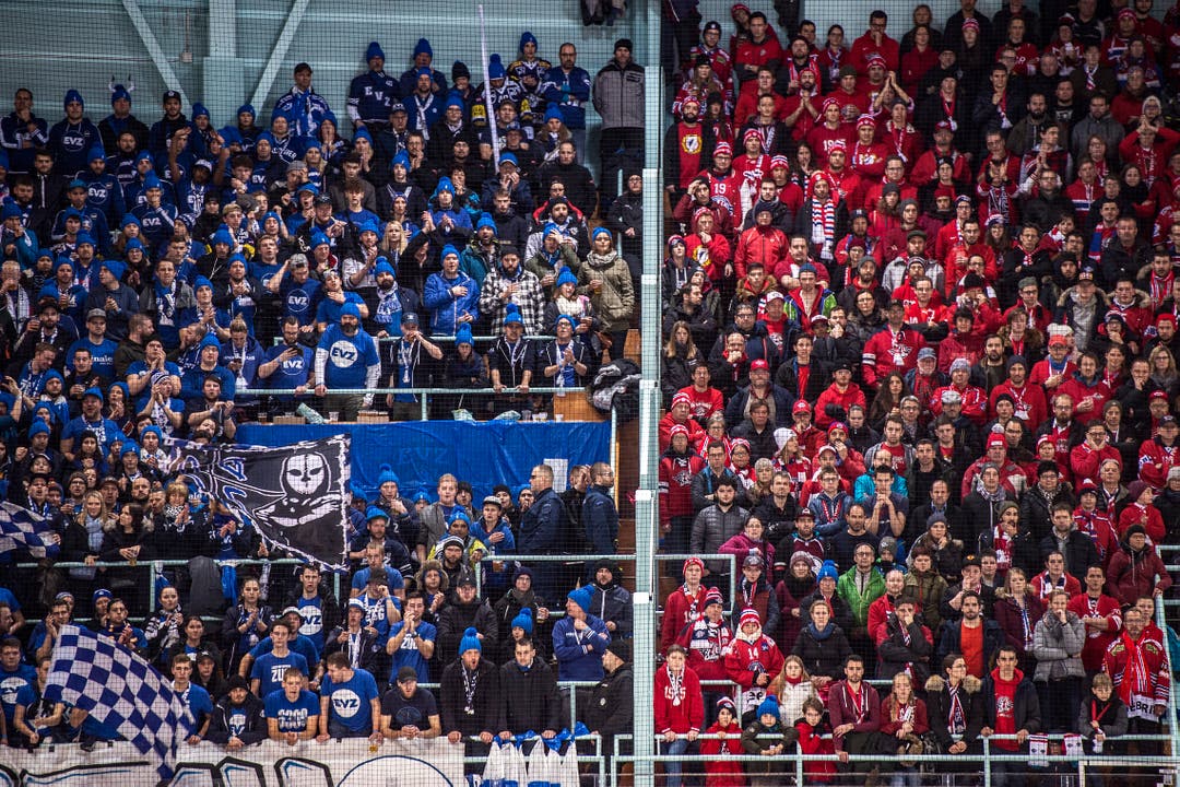 Die Zuger Fans unterstutzen ihr Team in Blau, die Rapperswil Fans in Rot, waehrend dem Cup-Final in Rapperswil-Jona. (KEYSTONE/Melanie Duchene)