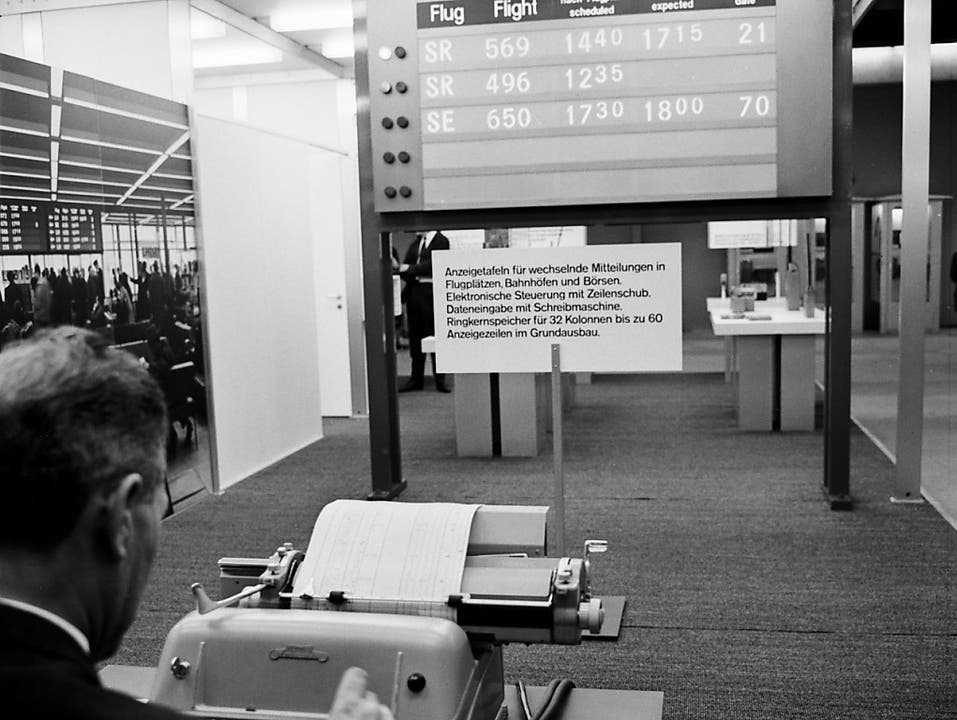 Präsentation einer Anzeigetafel für wechselnde Mitteilungen an Flugplätzen, Bahnhöfen und Börsen mit elektronischer Steuerung und Dateneingabe mit der Schreibmaschine an der 48. Mustermesse im Jahr 1964. (Bild: KEYSTONE/STR)