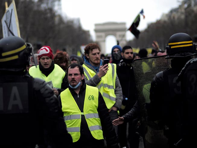 Teilnehmer der «Gelbwesten»-Proteste auf den Champs-Elysées am Samstag. (Bild: KEYSTONE/AP/KAMIL ZIHNIOGLU)