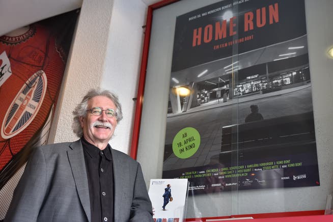 Der Werdenberger Filmemacher Kuno Bont vor dem Plakat seines neuen Werks «Home Run – Ein Dorf träumt Stadt». (Bilder: Heini Schwendener)