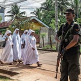 Ein Soldat bewacht eine Strasse, auf der sich Nonnen zu einem Massenbegräbnis in der St. Sebastian-Kirche begeben. (Bild: Carl Court/Getty (Negombo, 23. April 2019))