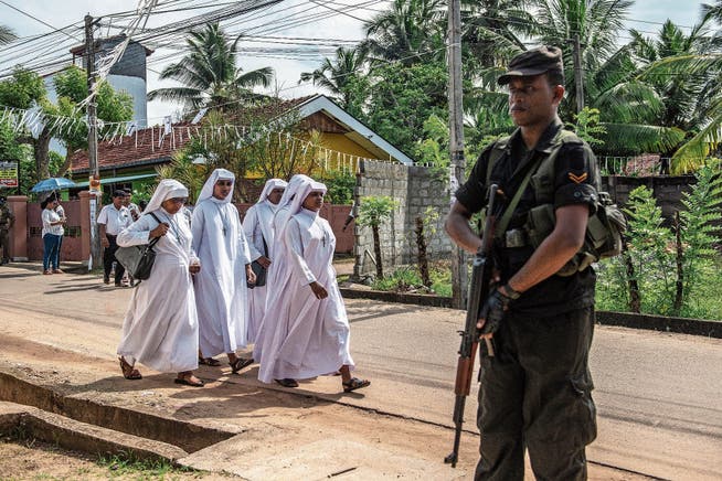 Ein Soldat bewacht eine Strasse, auf der sich Nonnen zu einem Massenbegräbnis in der St. Sebastian-Kirche begeben. (Bild: Carl Court/Getty (Negombo, 23. April 2019))