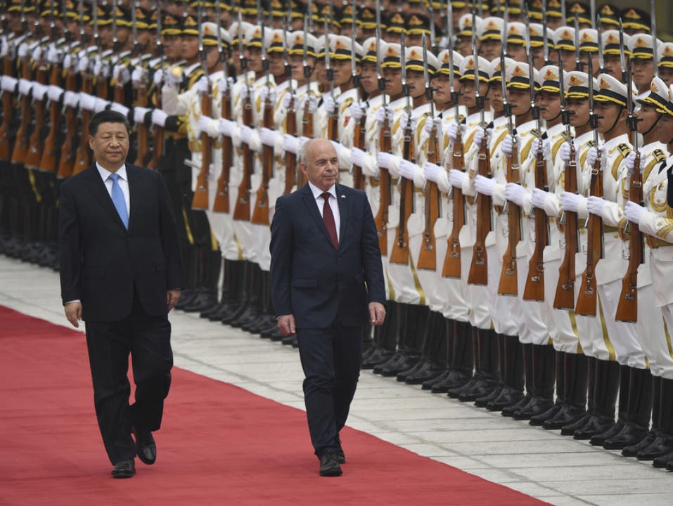 Bundespräsident Ueli Maurer und der chinesische Präsident Xi Jinping schreiten die Ehrengarde ab. (Bild: Keystone/AP/MADOKA IKEGAMI)