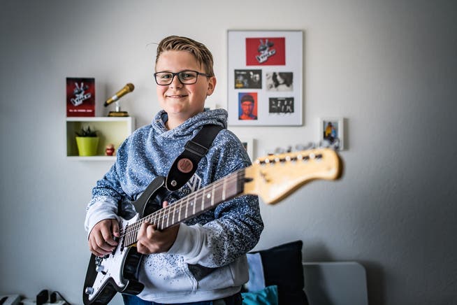 In seinem Zimmer übt Nevio täglich auf seiner Gitarre. Eine Wand hat er geschmückt mit Autogrammkarten und Fotos von «The Voice». (Bild: Michel Canonica)