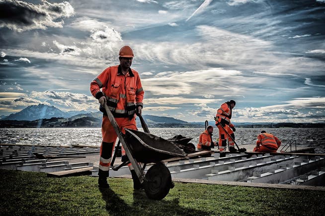 Werkhofmitarbeiter der Stadt Zug bauen einen neuen Holzliegerost in der Badi Seeliken. (Bild: PD)