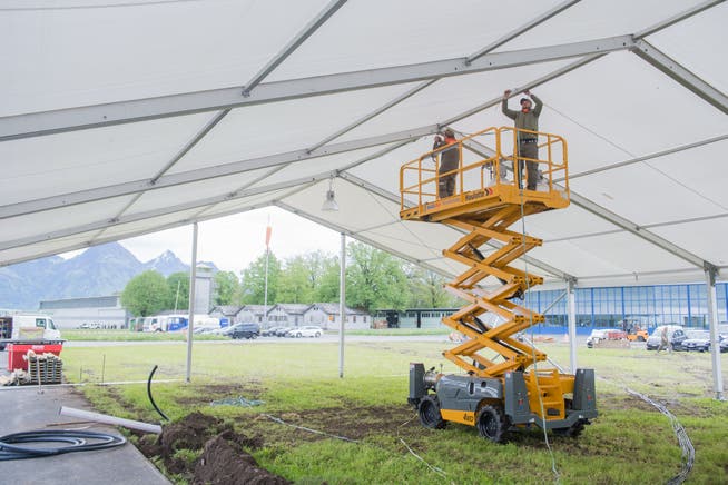 Über vier Wochen lang arbeitet der Zivilschutz Nidwalden für die Iheimisch auf dem Flugplatz Buochs. Beim Aufstellen der Zelte kommt auch eine Hebebühne zum Einsatz.(Bild: Manuela Jans-Koch, Buochs, 22. Mai 2019)