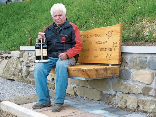 Initiant und Erbauer Hans von Allmen mit dem Weinhalter mit Monsteiner Weinen auf dem neuen Ruhebänklein. (Bild: pd)