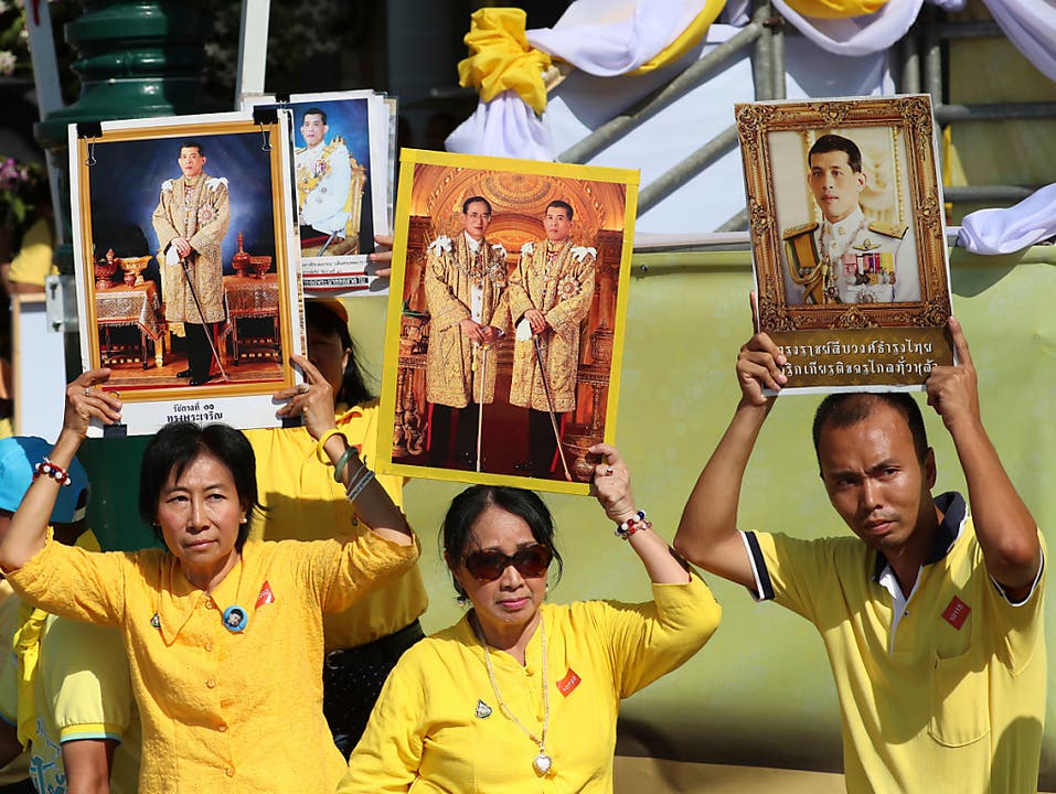 Lang lebe der König: Monarchisten in gelben Hemden halten Porträts ihrer neuen Königs in die Luft. (Bild: KEYSTONE/AP/SAKCHAI LALIT)