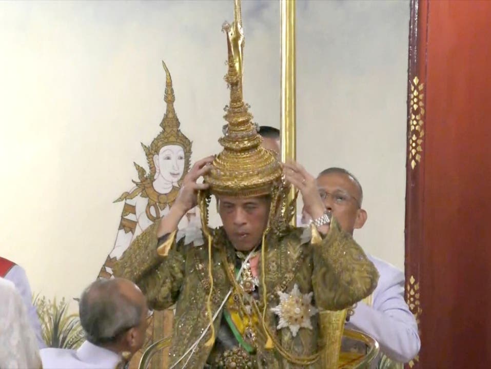 Der feierliche Moment: Thailands König Maha Vajiralongkorn setzt sich auf dem Thron sitzend die Krone auf. (Bild: KEYSTONE/AP Thai TV Pool)